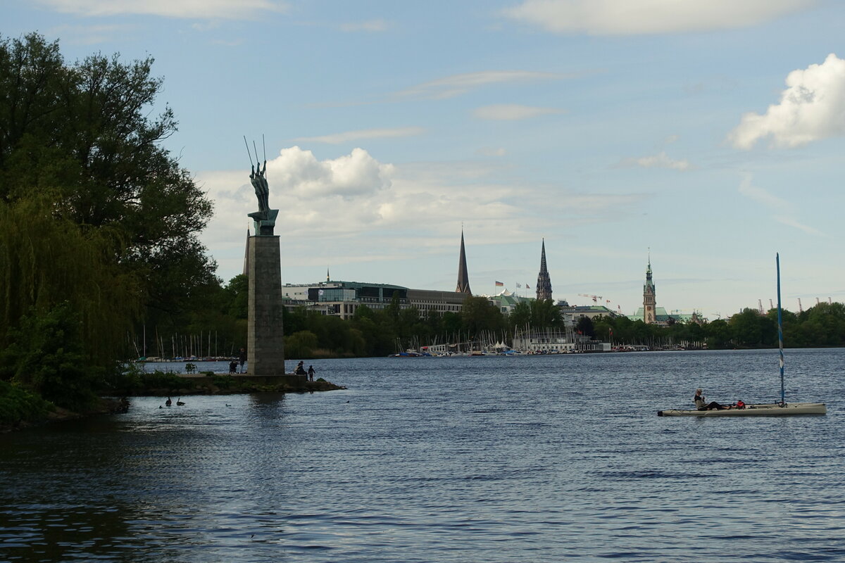 Hamburg am 24.5.2021: Blick vom Schwanenwik ber die Auenalster nach St. Georg, von links das Denkmal „Drei Mnner im Boot“, die Petrikirche, die Nikolaikirche und das Rathaus /