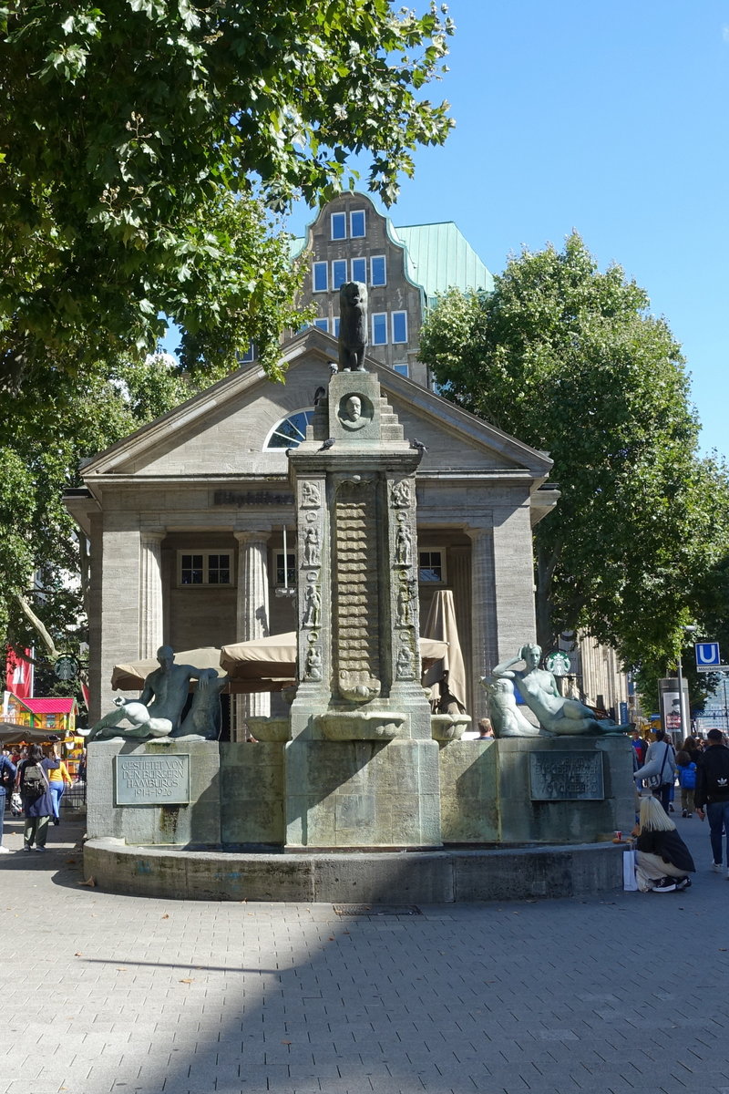 Hamburg am 5.9.2020: Der Mnckebrunnen und das dahinter liegend Gebude wurden vom damaligen Oberbaudirektor Fritz Schumacher entworfen und 1926 fertiggestellt. Die Bronzen stammen aus der Werkstatt des Knstlers Georg Wrba. Das Gebude mit den Sulen eine ffentliche Bcherhalle und wurde 2009 in ein Kulturcaf umgewandelt. Das enseble entstand zum Gedenken an Hamburger Brgermeister Johann Georg Mnckeberg (1839-1908)