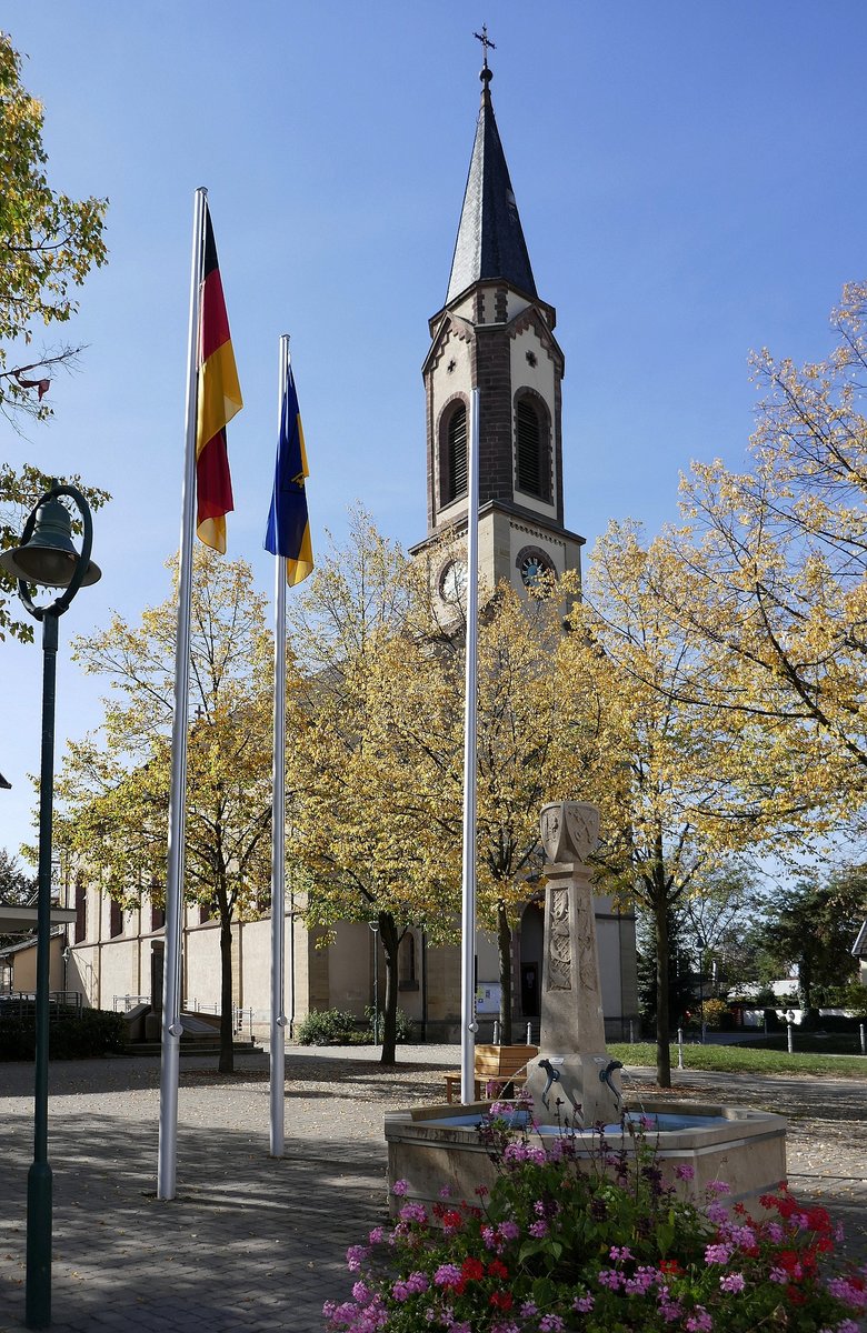 Hartheim, Blick ber den Dorfplatz mit Brunnen zur Kirche St.Peter und Paul, Okt.2018