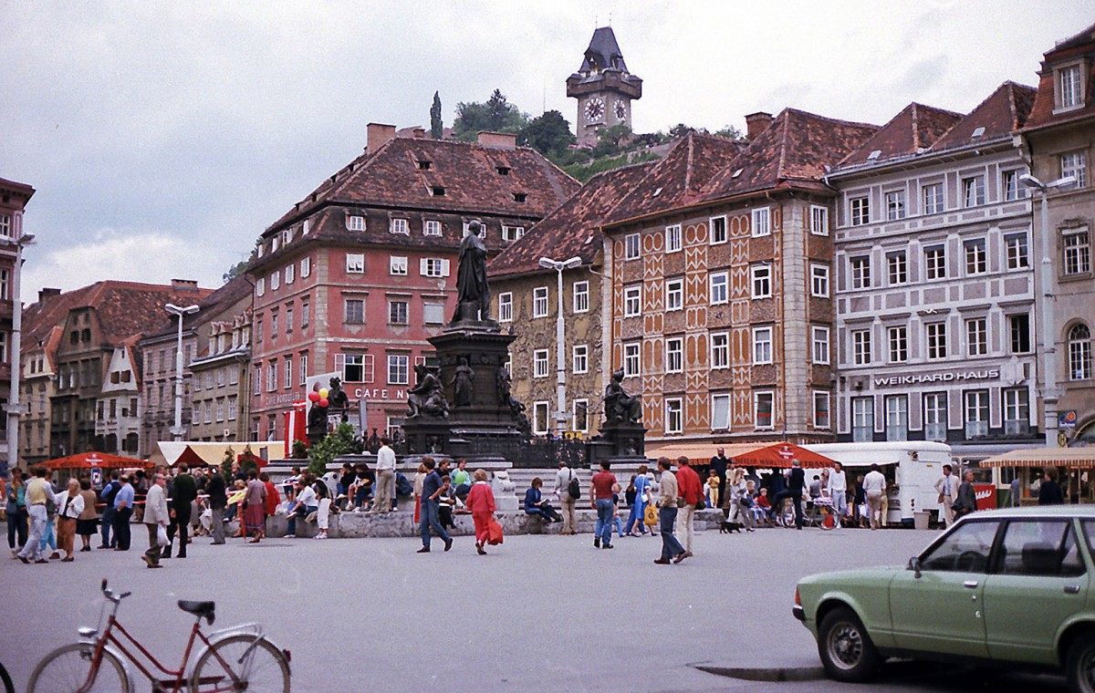 Hauptplatz in Graz mit dem Schlossberg und dem Uhrturm im Hintergrund. Aufnahme: Juli 1984 (digitalisiertes Negativfoto).