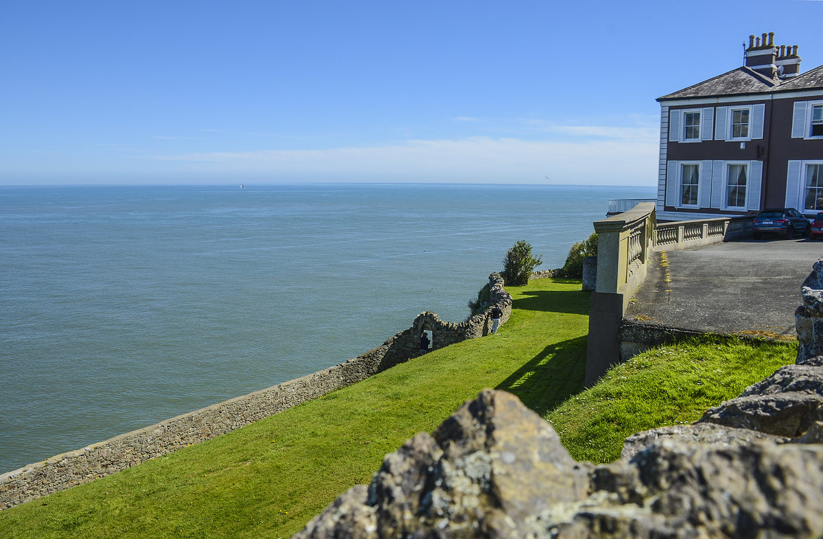 Haus und Steinzune am Balscadden Road in der Kleinstadt Howth stlich von Dublin. Aufnahme: 12. Mai 2018.