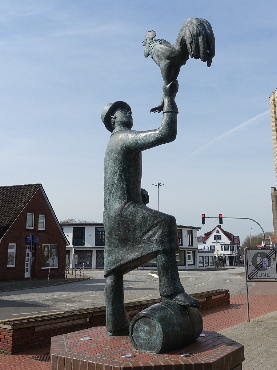 Heide/Holstein am 10.4.2023: Am Ende der Sderstrae steht die gusseiserne Figur des Hahnbeermanns, von Siegfried Assmann, das an die seit 1841 bestehende Tradition des Sdereggen-Hahnbeer mit Boelkugel, Hahn und Holztonne, Bis heute ist das Hahnbeer (plattdeutsch fr Hahnenfest) ein Hhepunkt im Heider Kalender.