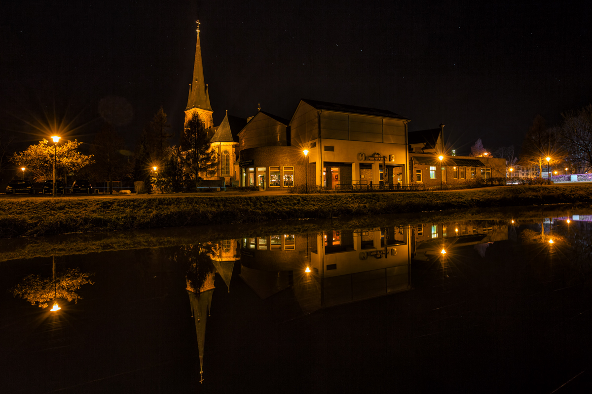 Herbstliche Spiegelung auf der Uecker in Torgelow mit der Christuskirche und des Irish Pub's OLD FIRE STATION und darber zeichnet sich der Sternenhimmel ab. - 24.11.2016 
