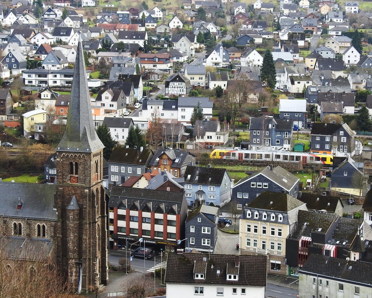 HERDORF/HELLERTAL/LK ALTENKIRCHEN MIT HELLERTALBAHN
HERDORF,1344 erstmals urkundlich erwhnt,war eines der Zentren des Bergbaus im SIEGERLAND mit den meisten
Bergwerken auf einem Ortsgebiet des Siegerlandes.Die FRIEDRICHSHTTE,vor 50 Jahren geschlossen,war hier
eine bedeutende Httenanlage.
HERDORF war auch Geburtsort eines der bedeutendsten Fotografen des 20. Jahrhunderts,AUGUST SANDER,
dessen fotografisches Werk Weltgeltung erlangte.
Die HELLERTALBAHN mit ihrer Strecke BETZDORF-HAIGER-DILLENBURG,von der HLB unter der Liniennummer
RB 96 betrieben,durchquert die Ortsmitte- der Lint-Triebwagen ist gerade auf der Fahrt von BETZDOREF/SIEG nach NEUNKIRCHEN/SIEGERLAND....Aufgenommen am 26.1.2018 vom Kreuz auf dem LEY-FELSEN,etwa in Hhe der
Kirchturmspitze der kath. Pfarrkirche ST. ALOISIUS.....