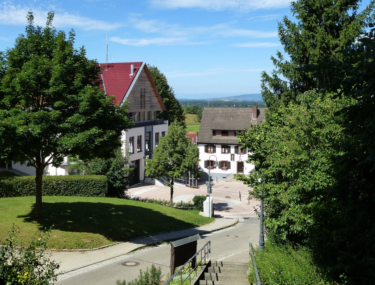 Heuweiler, Blick von der hochgelegenen Dorfkirche St.Remigius auf das Gemeindehaus links und das Gasthaus  Rebstock  rechts, Juli 2017