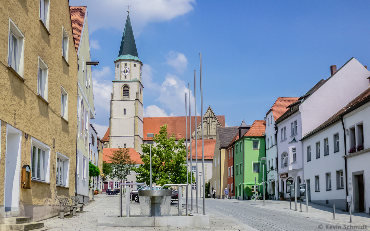 Hier ist der Obere Markt der Stadt Nabburg zu sehen. Der Brunnen im Vordergrund ist der 2002 eingeweihte Castillon-Brunnen. Zentral in der historischen Altstadt gelegen ist die gotische Stadtpfarrkirche St. Johannes der Tufer, die um die Jahrhundertwende 13./14. Jahrhundert erbaut wurde. (10.07.2013)