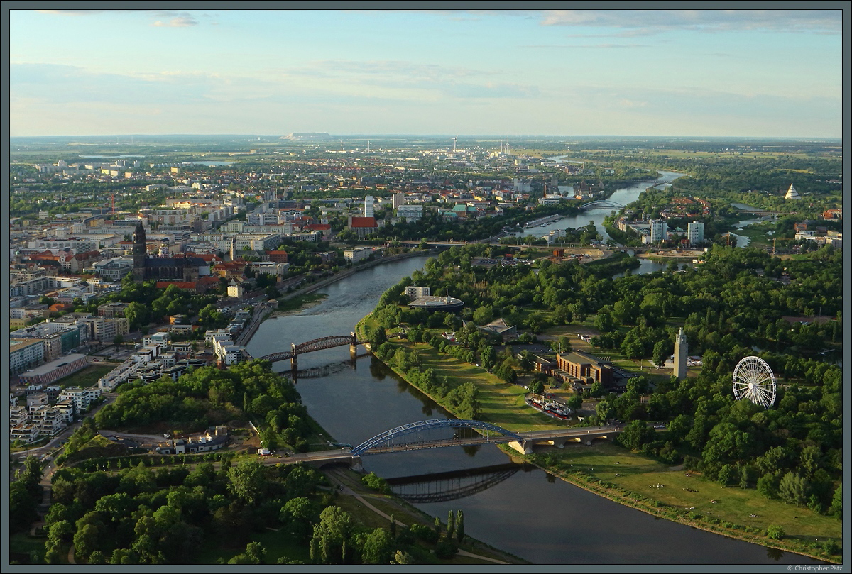 Im Zentrum von Magdeburg verzweigt sich die Elbe in mehrere Flussarme, deren grter die Stromelbe ist. Sie fliet direkt am Dom entlang und wird unter anderem von der Sternbrcke (im Vordergrund) und der Hubbrcke (dahinter) berquert. Rechts befindet sich der Rotehornpark mit der Stadthalle und dem Albinmllerturm. Rechts im Hintergrund ist der Jahrtausendturm zu sehen. (Aufgenommen am 29.05.2020 aus einem Ballon)