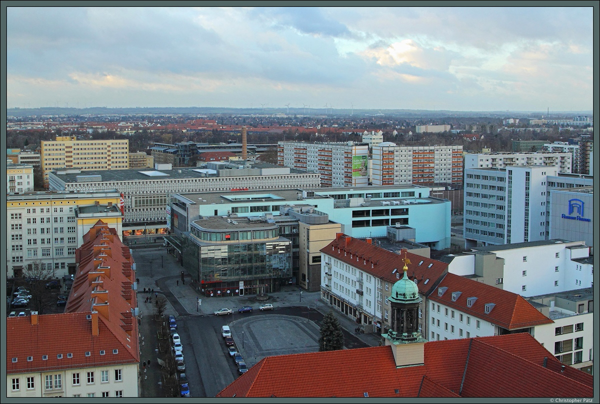 Im zweiten Weltkrieg wurden groe Teile der Magdeburger Altstadt zerstrt, nur wenige historische Gebude blieben erhalten. Auch der Alte Markt ist berwiegend von Gebuden aus der Nachkriegszeit geprgt. Vom Turm der Johanniskirche blickt man Richtung Westen ber das im 17. Jahrhundert errichtete Rathaus zum ehemaligen Centrum-Warenhauses, in dem sich heute eine Karstadt-Filiale befindet. Quer vor dem Kaufhaus verluft der Breite Weg, welcher vor der Zerstrung im Krieg als schnste Barockstrae Deutschlands galt. Heute ist der Breite Weg in diesem Bereich eine Fugngerzone und wird als Einkaufsstrae genutzt. (Magdeburg, 04.01.2015)