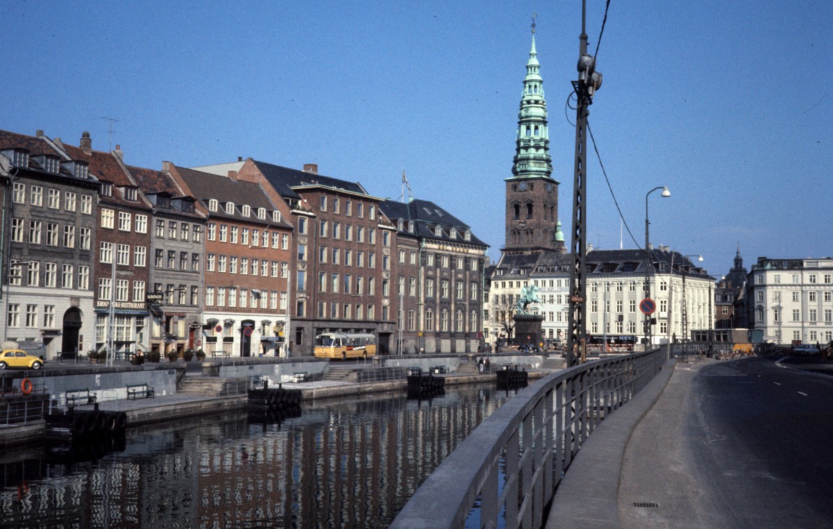 Kbenhavn / Kopenhagen eines Sommertages in den 1970er Jahren: Zu sehen sind die Strasse Gammel Strand (:  Altes Ufer ) auf der linken Seite des Kanals, ein Teil des Hjbro Plads mit dem Reiterstandbild vom Bischof Absalon und der Turm der Sankt Nikolaj Kirke, die seit 1805 keinen kirchlichen Zwecken dient.