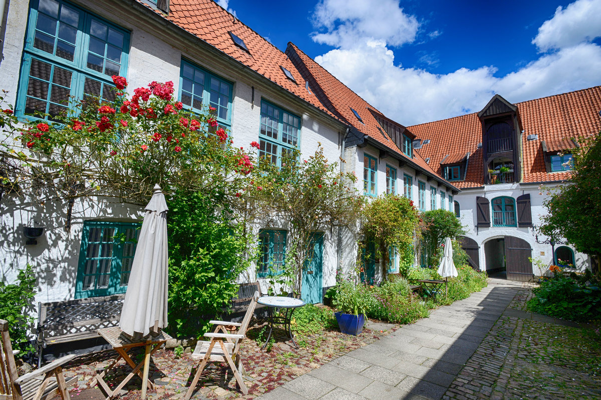 Kaufmannshof, Norderstrae 86 in Flensburg. Dieser Kaufmannshof ist ein typischer Handelshof aus dem 18. Jahrhundert. Im Querspeicher zur Hafenseite wurden die Waren gelagert. Im Hof erfolgte die Verarbeitung der Waren. Hier befanden sich die Unterknfte des Gesindes, die Viehstlle und die Brunnenanlage. Die Kaufherren wohnten im Vorderhaus zur Norderstrae. Aufnahme: 11. Juli 2020.