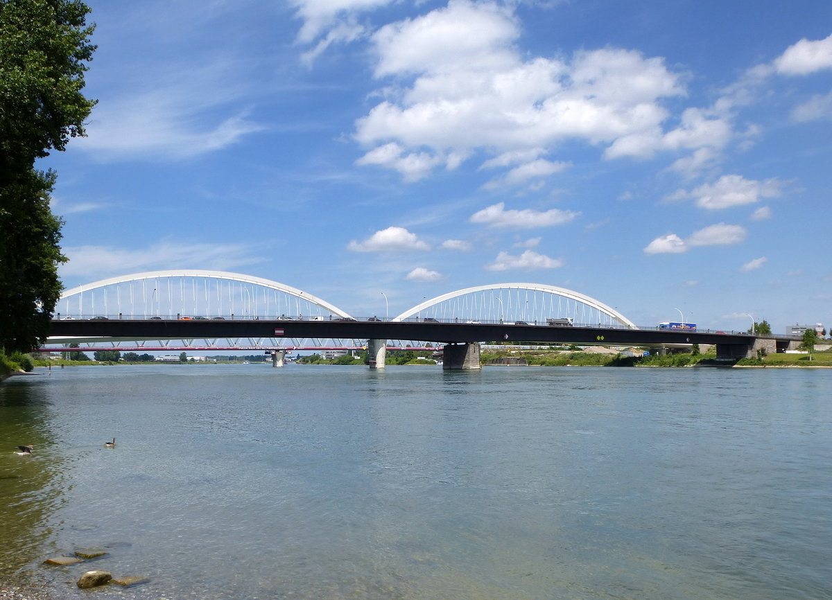 Kehl, Blick vom franzsischem Ufer auf die drei dicht nebeneinander liegenden Rheinbrcken, im Vordergrund die 1960 erbaute vierspurige Europabrcke, dahinter die im Bau befindliche Stahlbogenbrcke fr die neue Straenbahnverbindung, und ganz hinten die zweigleisige Eisenbahnbrcke, Juli 2016