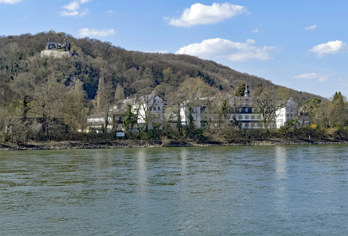 Kloster und Gymnasium Nonnenwerth auf der gleichnamigen Rheininsel bei Bad-Honnef, in Hintergrund links oben auf dem Berghang die  Burgruine Rolandseck - 30.03.2019