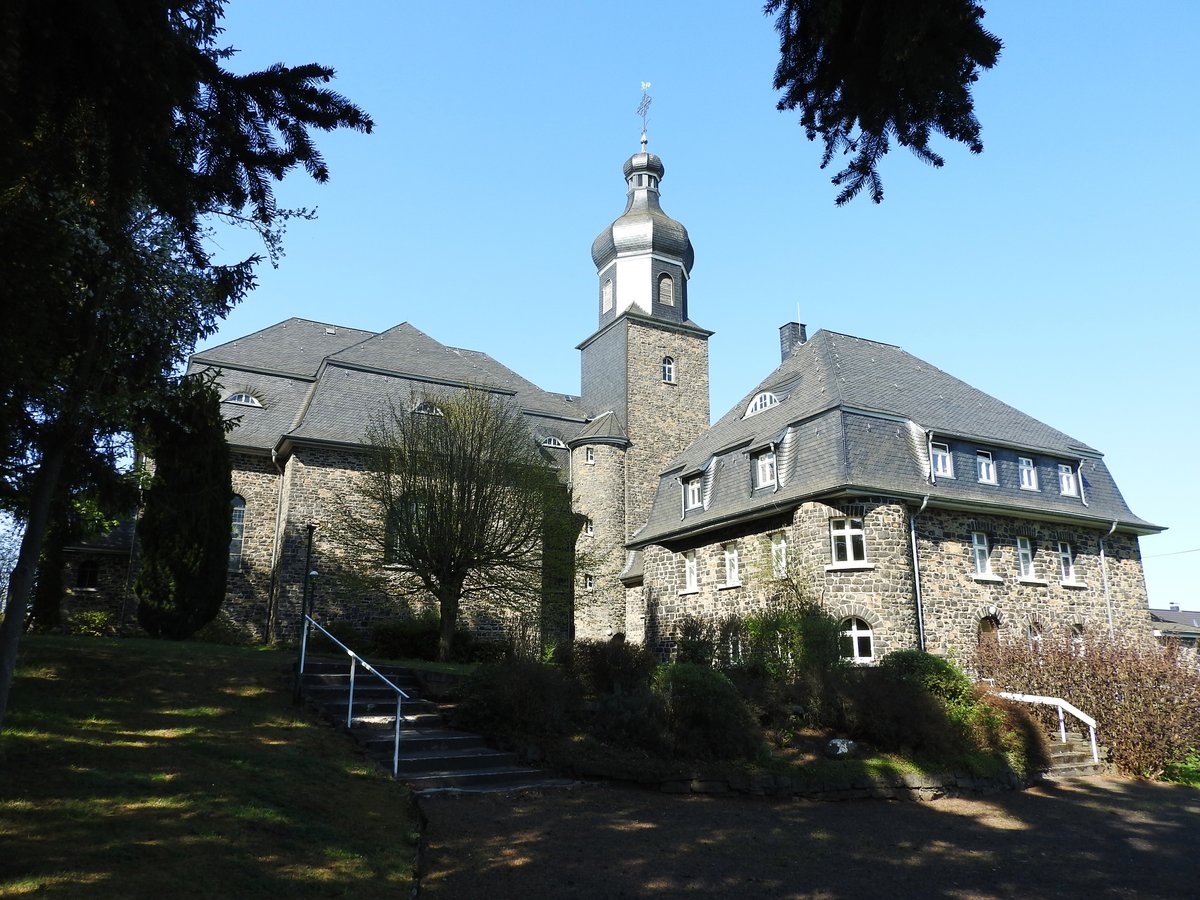 LANGENHAHN/WESTERWALD-KATH. PFARRKIRCHE  HERZ JESU 
Kommt man auf der B255 aus Richtung SIEGEN/RENNEROD in Richtung MONTABAUR,fhrt man direkt an
diesem wunderschnen und beeindruckenden Kirchenbau vorbei,der fast wie eine kleine Burganlage wirkt...
1922-24 aus heimischem Basalt im neobarocken Stil errichtet mit direkt angebautem Pfarrhaus
wirkt das Gotteshaus wie eine Manifestation von unerschtterlichem Westerwlder Glauben,
hier am 20.4.2018....