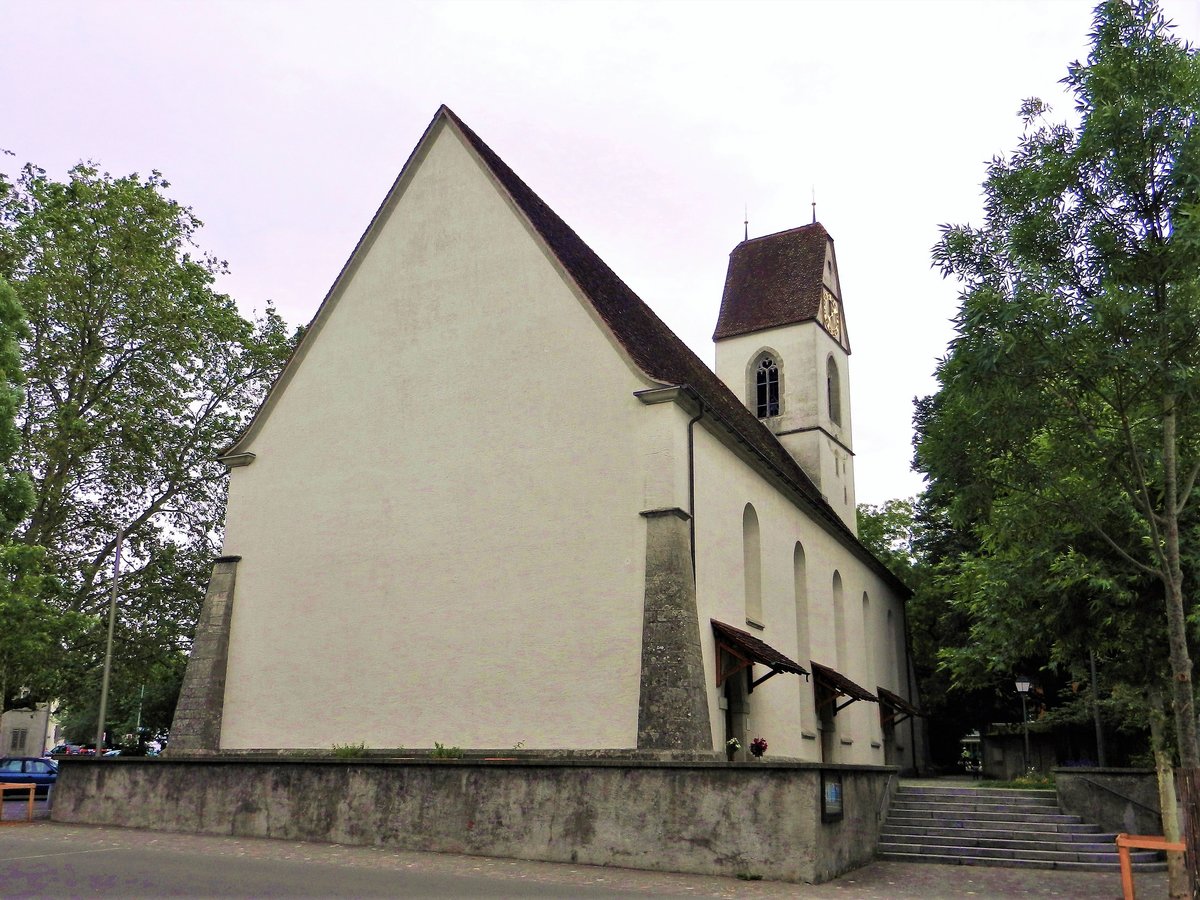 Lenzburg, reformierte Kirche, südliche Seitenfassade mit den sich nach oben verjüngenden Eckstrebepfeilern und den Pultdächern über den drei Eingängen - 06.06.2012