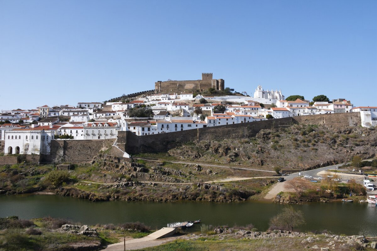 MRTOLA, 09.02.2022, Panoramabild mit Rio Guadiana im Vordergrund, dann die Burgmauer, dahinter die Altstadt und ber allem thront die Burg
