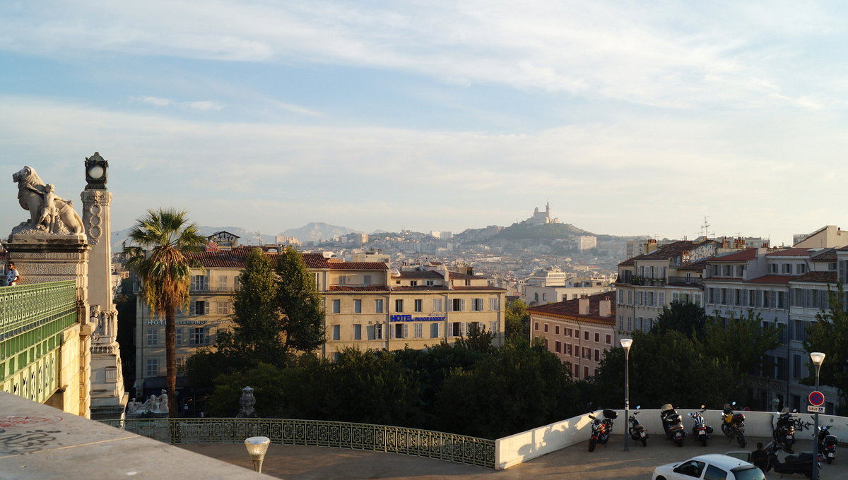 Marseille im goldenen Abendlicht: Blick vom Vorplatz des Bahnhofes St-Charles nach Sden. Im Hintergrund erkennbar ist die Basilika Notre-Dame-de-la-Garde, die mit der goldenen Marienstatue von Lequesne gekrnt ist. 10.09.2018.