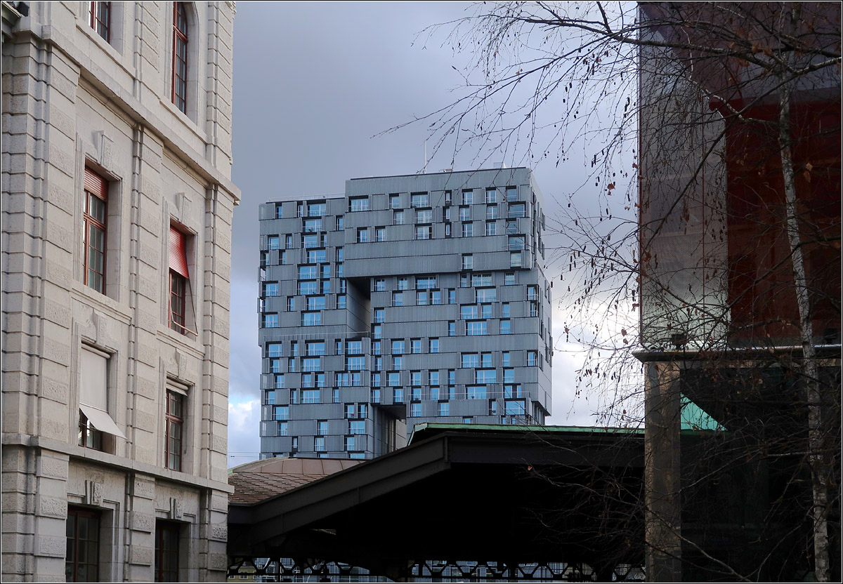 Moderne Architektur in Basel -

Durchblick zwischen dem Bahnhofsgebude des SBB-Bahnhofes und dem Elsssertorgebude zum Meret-Oppenheimer Hochhaus der Architekten Herzog & de Meuron auf der anderen Seite der Gleise. Je nachdem welche der beweglichen Fassadenelemente offen oder geschlossen sind ndert sich das Aussehen des Gebudes.

08.03.2019 (M)