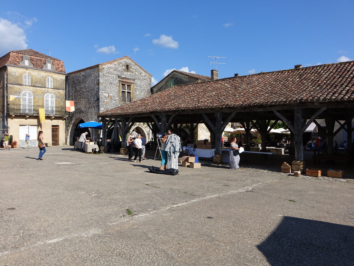 Monpazier, am Place de Arcades befindet sich ein Brunnen und die aus Kastanienstmmen gezimmerte Markthalle aus dem 16. Jahrhundert (22.07.2018)
