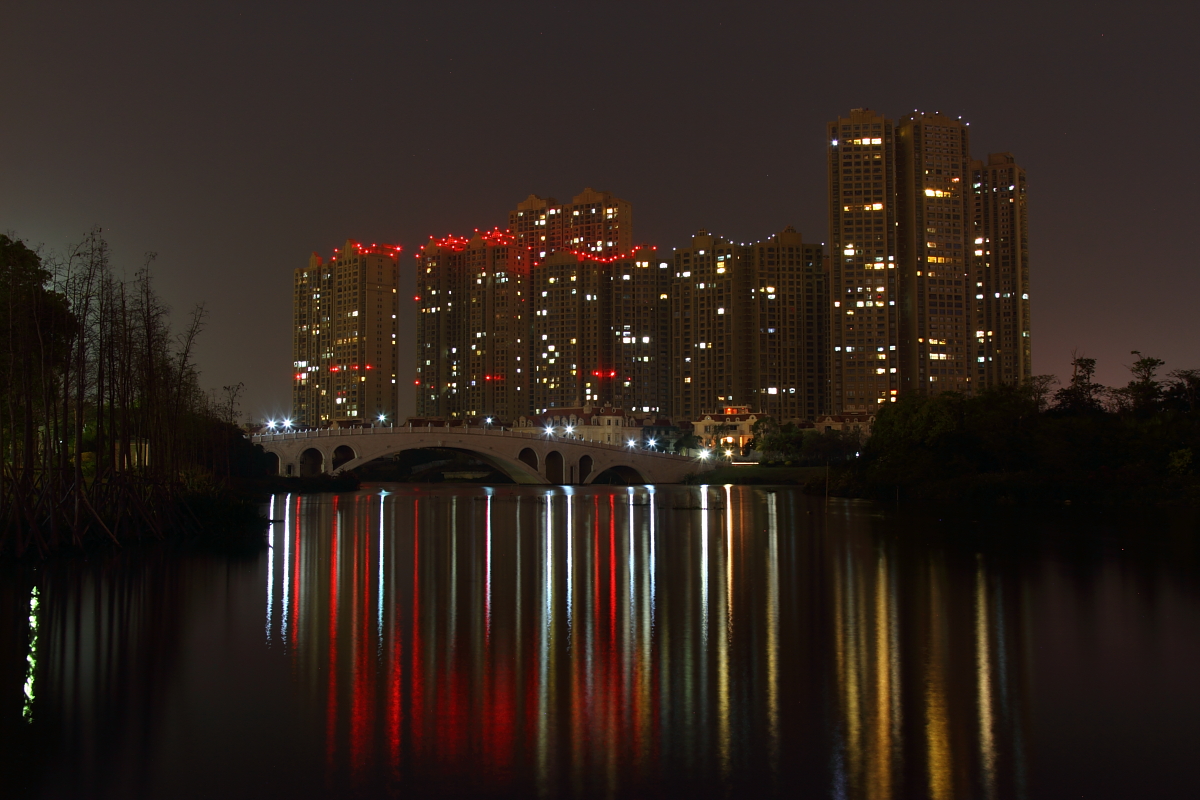 Nchtlicher Blick ber den Qinggou Ditch in Jinjiang, Quanzhou auf eine Hochhaussiedlung am 07.04.2107.