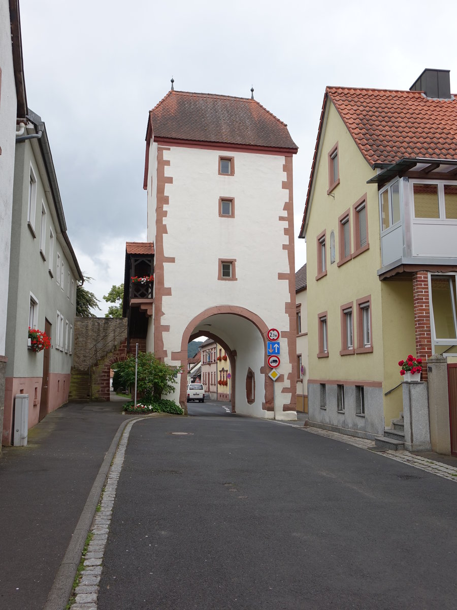 Neubrunn, Torturm der Ortsbefestigung, Durchfahrt mit Rundbogen und Spitzbogen, darber drei Geschosse und Halbwalmdach, Mitte 15. Jahrhundert (15.06.2016)