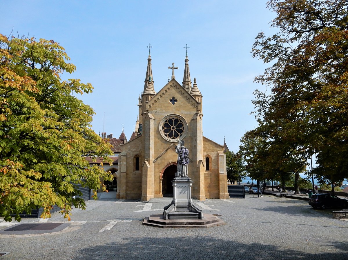 Neuchtel, neben dem Schloss, die Kollegiatkirche, Hauptportal und Kirchenhof mit Statue des Reformators Guillaume Farel. Die Kirche ist ein reformiertes Gotteshaus, war einst Stiftskirche und Maria geweiht - 08.09.2017