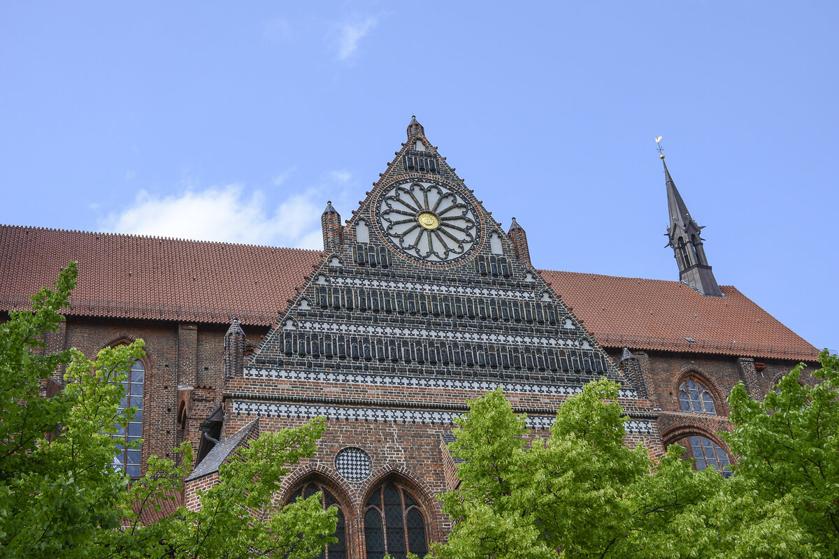 Nikolaikirche in der Hansestadt Wismar - Giebeldreieck des Sdquerhauses mit Mawerkrosette und Galerien von Relieffiguren aus Terrakotta. Aufnahme: 18. Juni 2022.
