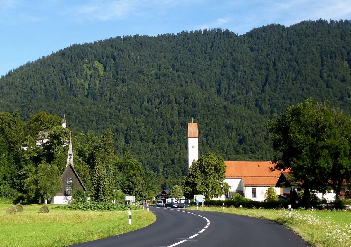 Oberau im Zugspitzland, drei Kirchen begren die Besucher am Ortseingang, rechts die katholische Pfarrkirche St.Ludwig, links die 1962 eingeweihte evangelische Heilandkirche und auf dem Berg die barocke St.Georgs-Kapelle, Aug.2014