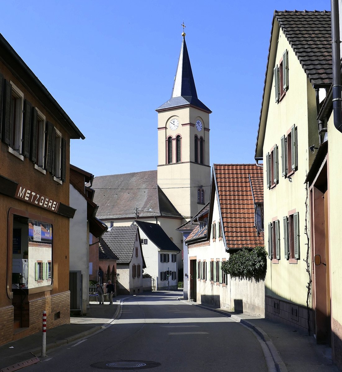 Oberrotweil im Kaiserstuhl, Blick durch die Hauptstrae zur katholischen Pfarrkirche St.Johannes Baptist, Mrz 2020