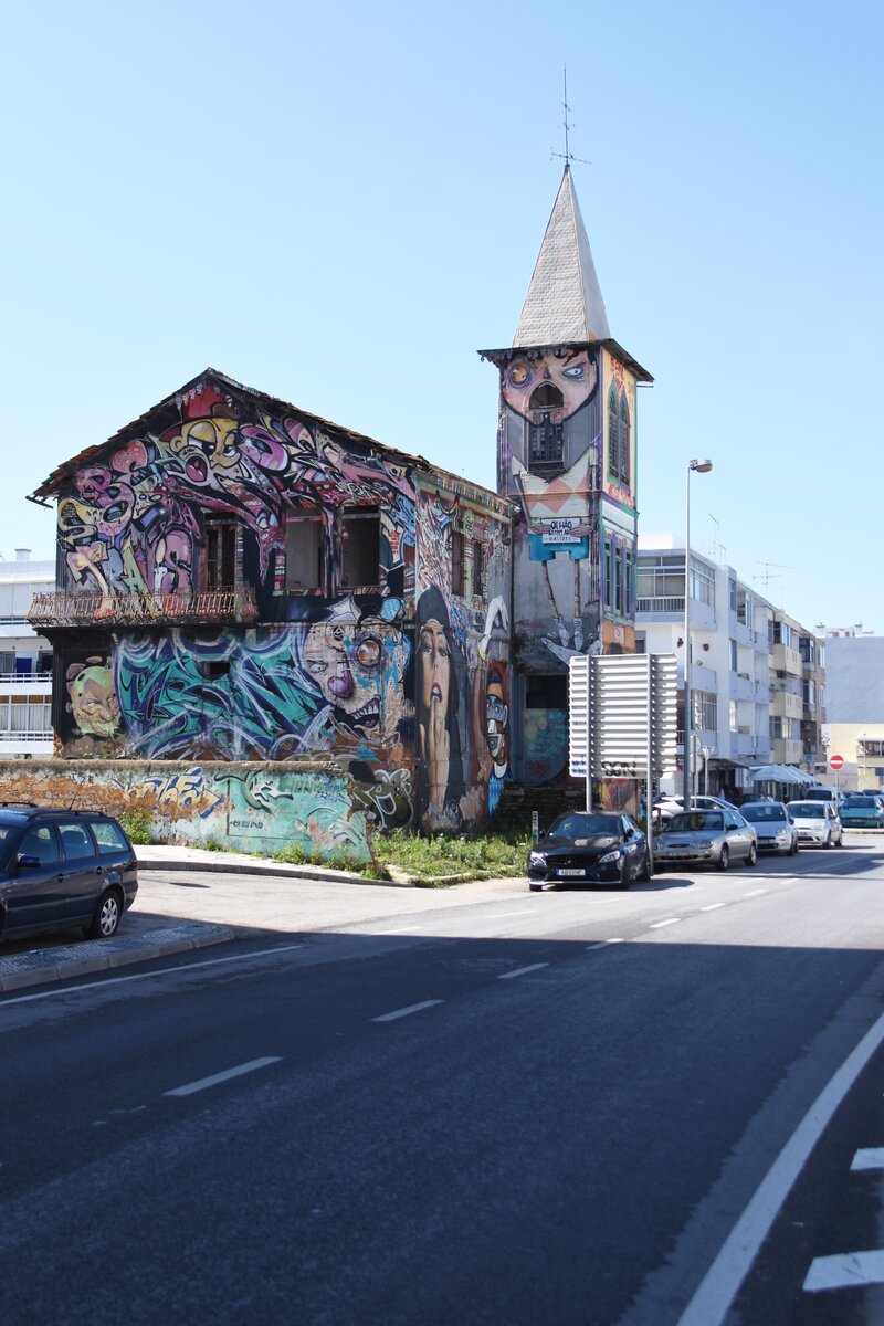 OLHO, 06.03.2022, mit Graffiti verziertes, unbewohntes Haus an der N-125, was jedenfalls besser aussieht, als wenn das Haus unverziert vor sich hingammeln wrde; ansonsten ist es in Portugal genauso schlimm wie in Deutschland: es gibt nichts, wo sich nicht mindestens ein  Knstler  zum Beschmieren findet