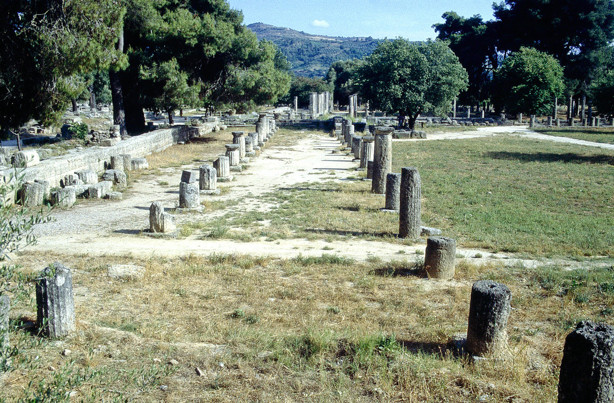 Olympia (griechisch Ὀλυμπία) war das Heiligtum des Zeus in Elis, im Nordwesten der Halbinsel Peloponnes. Es war der Austragungsort der Olympischen Spiele der Antike. Auf dem Bild ist das Gymnasien zu sehen. Bild vom Dia. Aufnahme: Juni 1992.