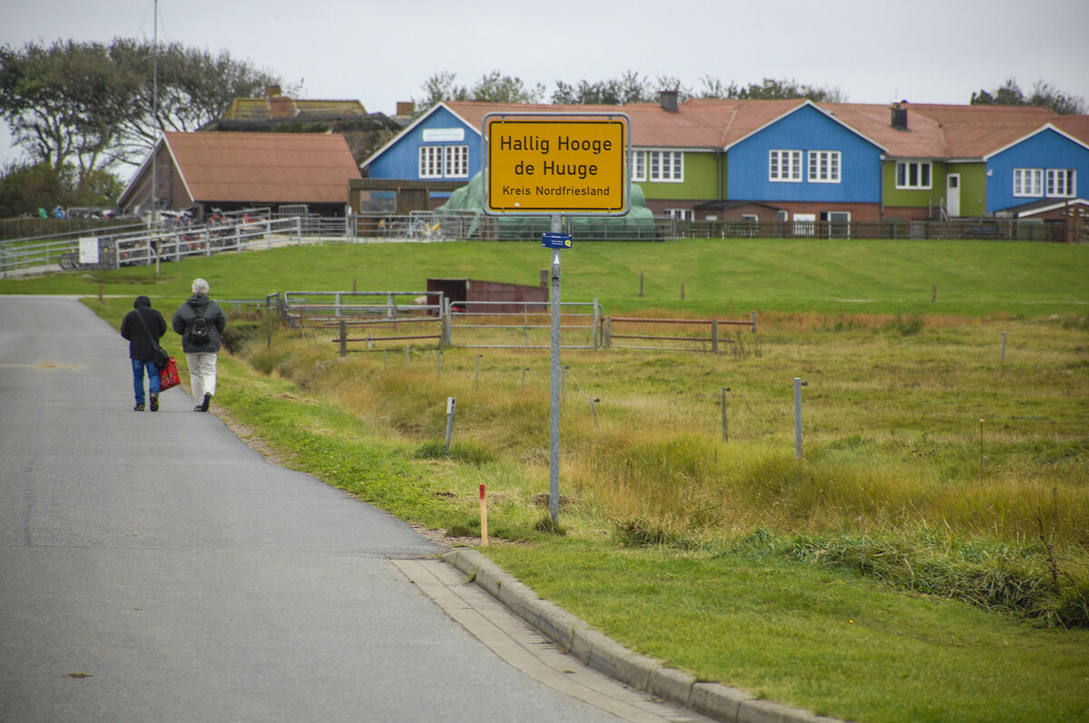 Ortsschild auf der Hallig Hooge. Im Hintergrund ist die Backenswarft zu sehen. Aufnahme: 4. Oktober 2021.