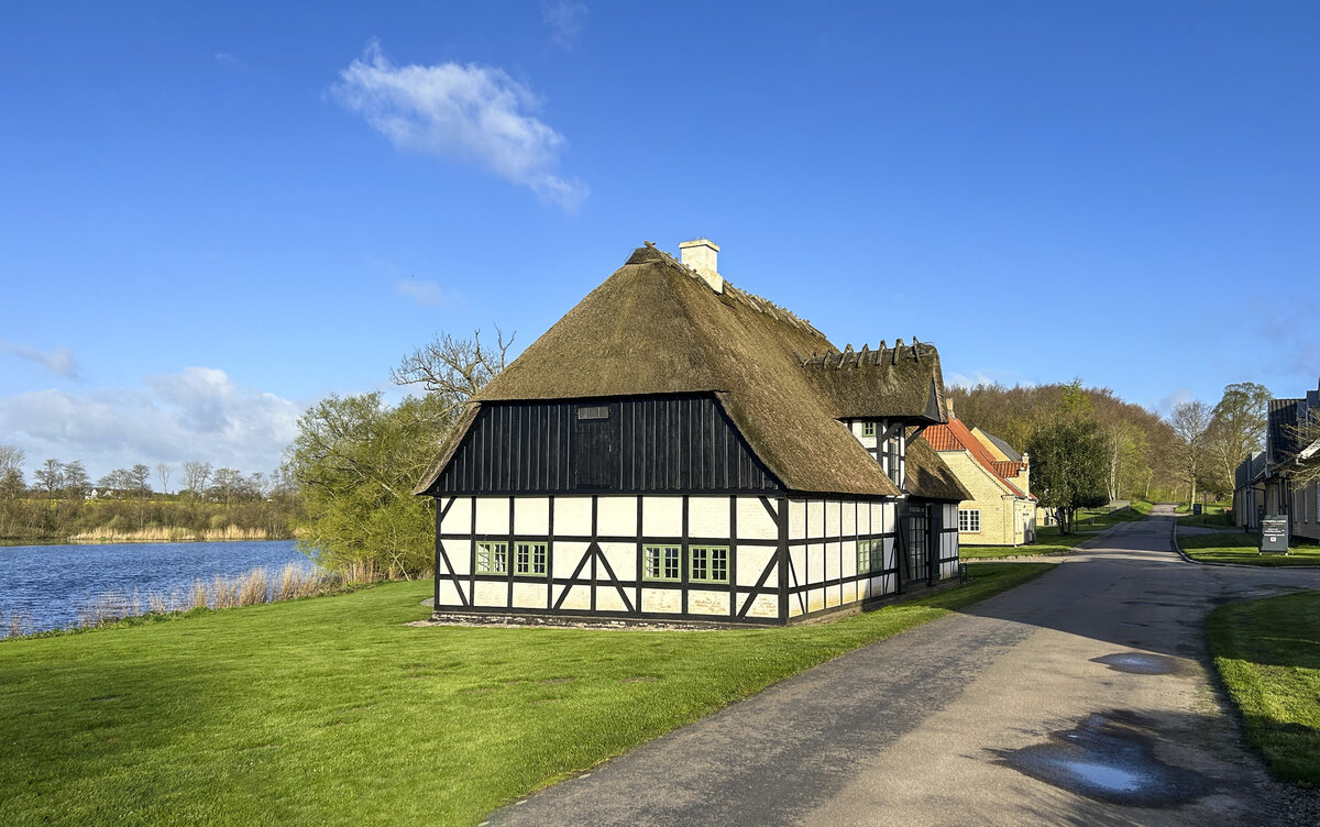 Reetgedecktes Fachwerkhaus am Schloss Sandbjerg (deutsch: Sandberg) nrdlich von Snderborg (Sonderburg) in Nordschleswig. Aufnahme: 14. April 2024.