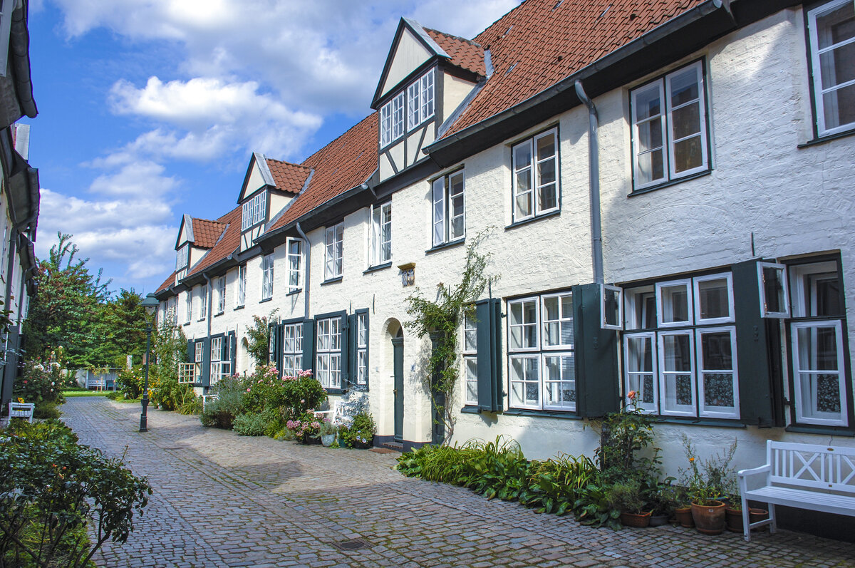 Reihenhuser am Glandorps Hof, Glockengieerstrae 45–53, Lbeck. Die Lbecker Hfe beruhen hufig auf Stiftungen wohlhabender Lbecker Brger. Hinter den giebelseitigen Straenhusern wurden damals die so genannten Buden errichtet, meist zweistckige Gebude mit einem Grundriss mit wenig mehr als einem Zimmer. Die Buden in den Gngen waren oft Wohnrume der Beschftigten des Gewerbes, das im Straenhaus ausgebt wurde. Aufnahme: 21. August 2021.