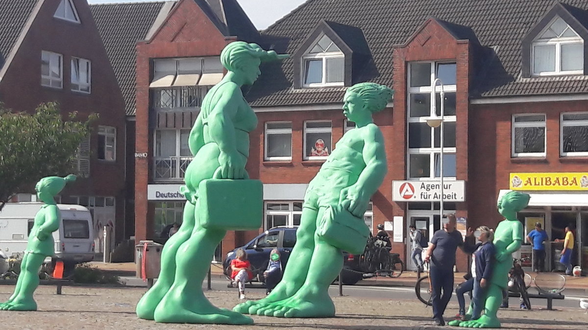 Reisenden Riesen . Grüne Schulkinder reisen aus. Seit 2001 stehen die Reisenden Riesen im Wind auf dem Bahnhofsvorplatz von Westerland auf Sylt. Am 10.06.2020  gesehen.