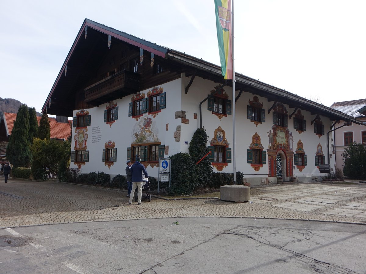 Ruhpolding, Rathaus, zweigeschossiger Massivbau mit Blockbaugiebel und Hochlauben, im Heimatstil erbaut 1922, Fassadenmalerei von 1925 (26.02.2017)