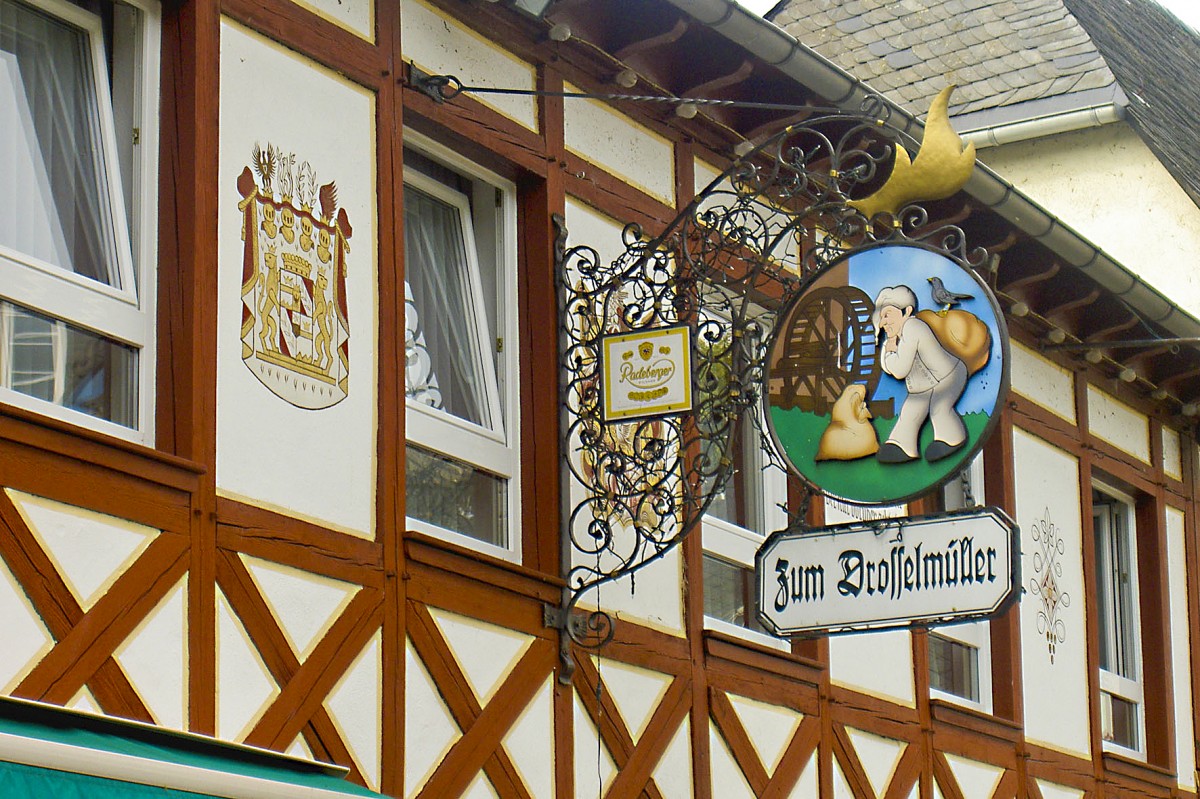 Schild und Fachwerk Zum Drosselmller in Rdesheim am Rhein. Aufnahme: Juli 2005.