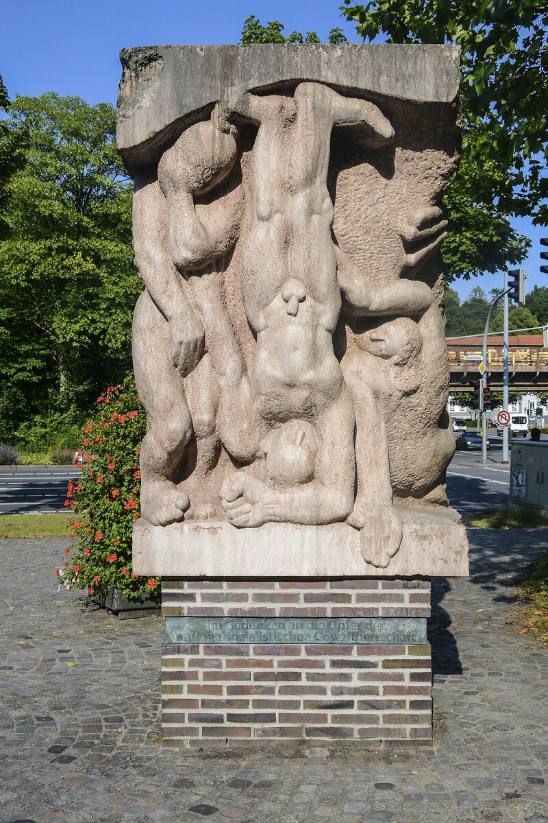 Skulptur an einem geschichtstrchtigen Ort: Das Hebroni-Denkmal vor dem Polizeigebude in Flensburg. Im benachbarten Reichspostgebude war zum Ende des Krieges ein provisorisches Studio des Reichssenders Flensburg eingerichtet, von dem aus am 7. Mai Johann Ludwig Graf Schwerin von Krosigk, Mitglied der letzten Reichsregierung, die bedingungslose Kapitulation der Wehrmacht ankndigte. Nachdem am 23. Mai dann auch die letzte Reichsregierung im Sonderbereich Mrwik verhaftet worden war, wurden Dnitz, Albert Speer und Alfred Jodl in den Freigngerhof des Polizeiprsidiums gebracht, wo die internationale Presse Fotos machen durfte. Aufnahme: 17. Juli 2022.