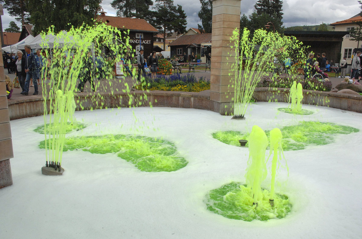 Springbrunnen mit grellen Farben auf dem Markplatz (schwedisch: Target) von Rttvik in Dalarna - Schweden.
Aufnahme: 31. Juli 2017.