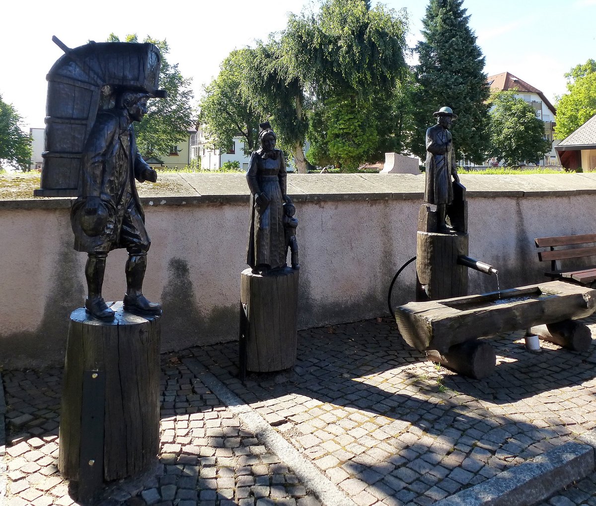 St.Mrgen, der Schwarzwaldbrunnen mit typischen Schwarzwaldfiguren am Rande der Friedhofsmauer, Juli 2015