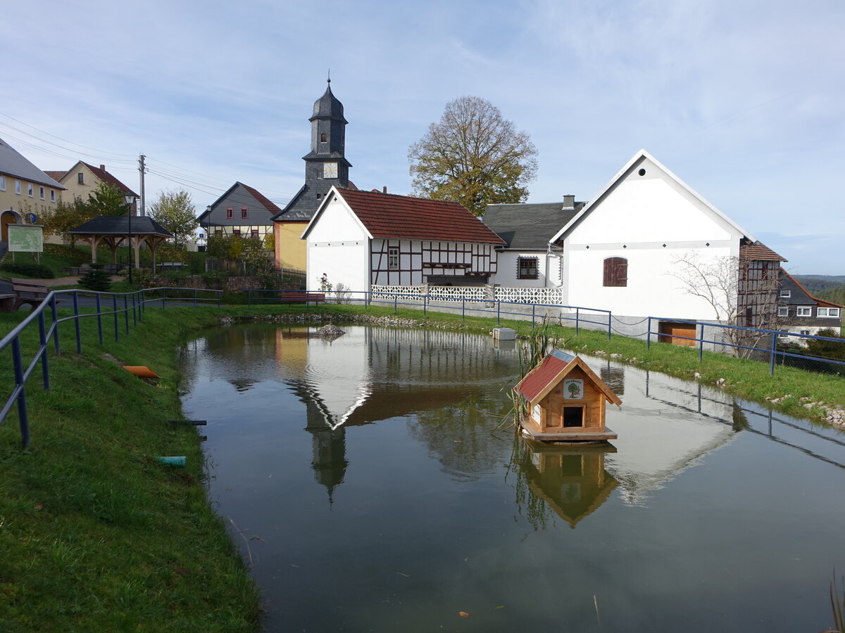 Strwitz, evangelische Kirche St. Stephanus und Huser am Dorfteich (23.10.2022)