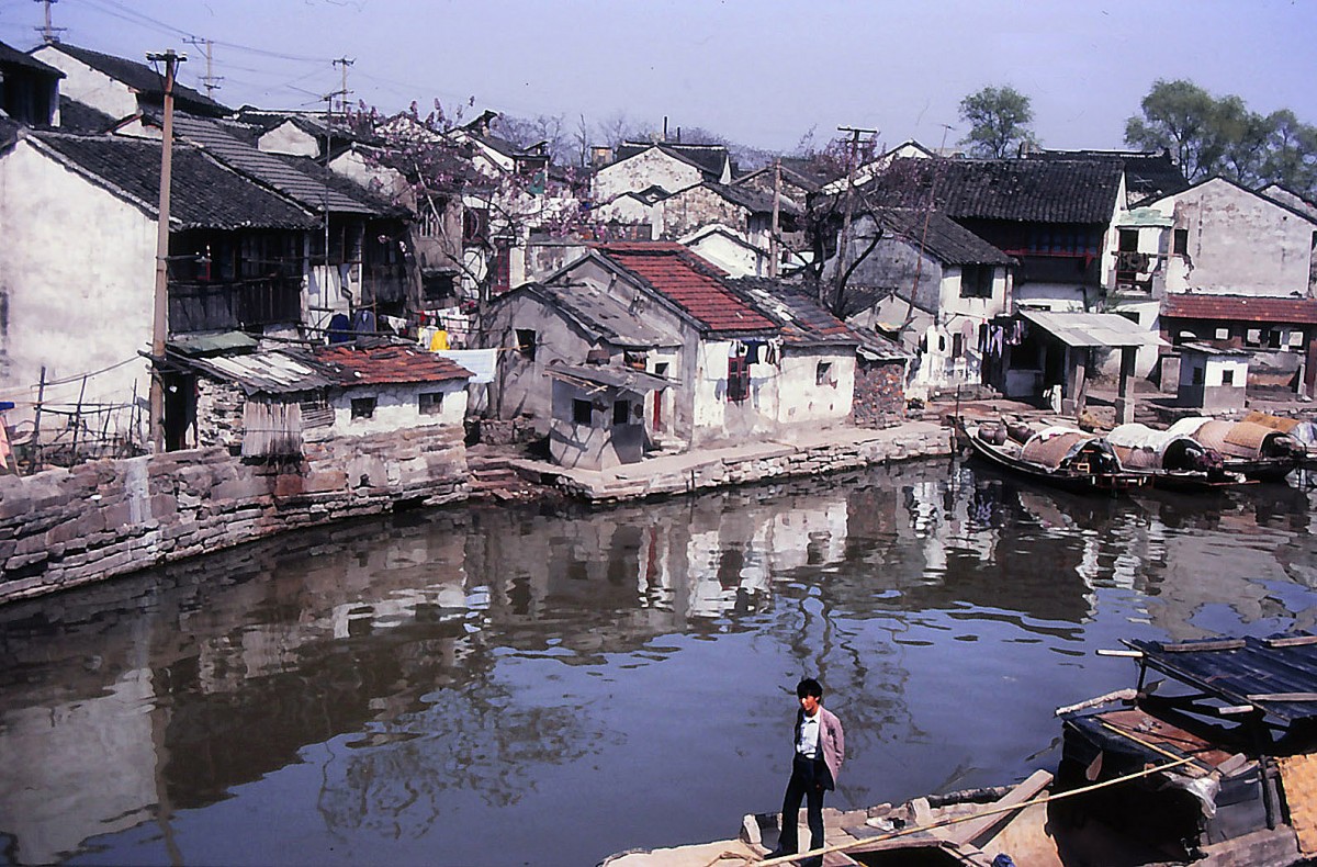 Suzhou (Jiangsu). Seit 1997 sind einige der Parks in das UNESCO-Weltkulturerbe aufgenommen. Zugleich verschwinden viele altertümliche Häuser, Kanäle und Brücken mit großer Geschwindigkeit, um der Moderne Platz zu machen. Aufnahme: April 1989 (Bild vom Dia).