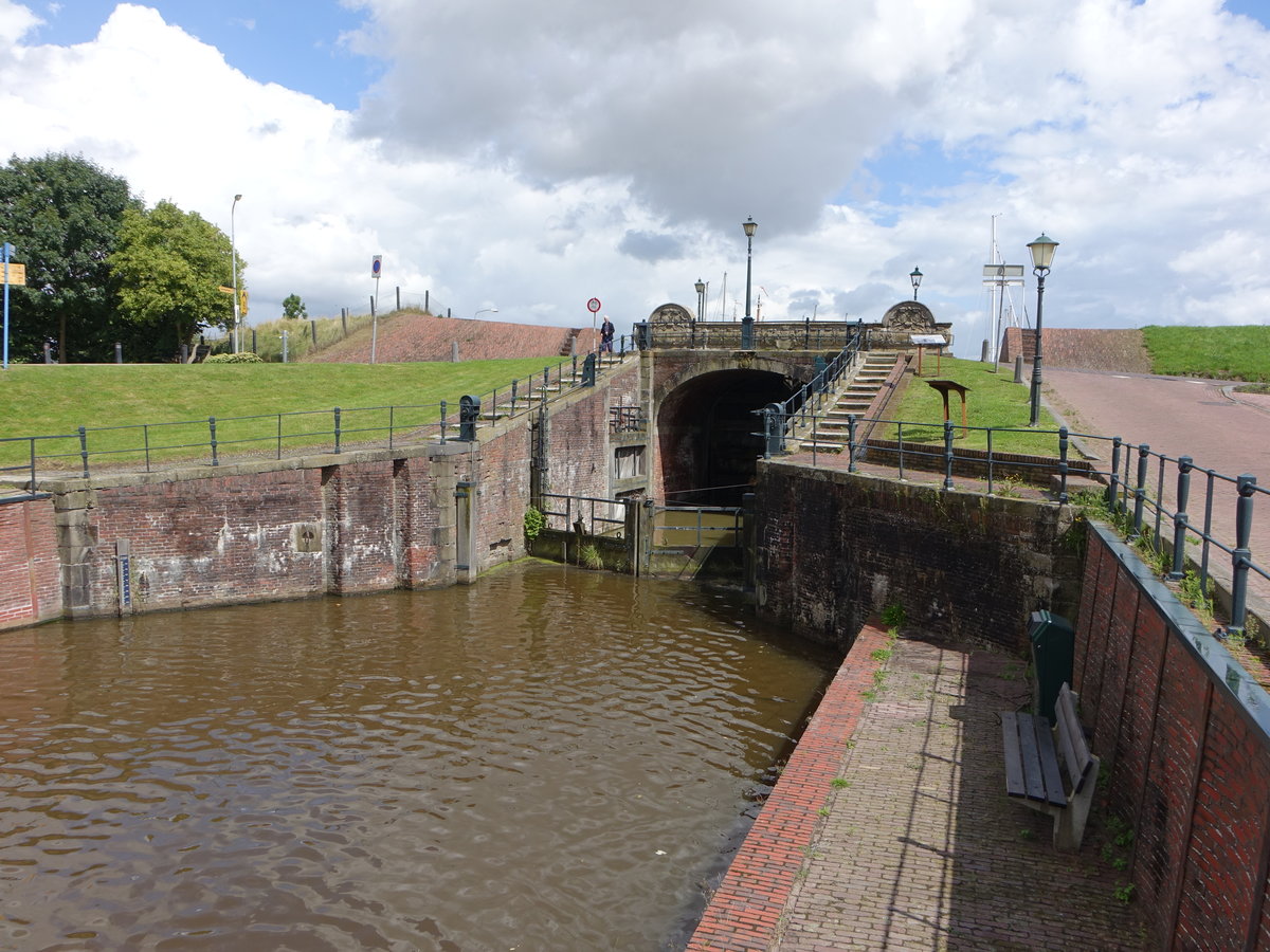 Termunterzijl, die Schleusenbrcke hat eine monumentale Brustwehr von 1724, reich mit Wappen und Kartuschen verziert (28.07.2017)