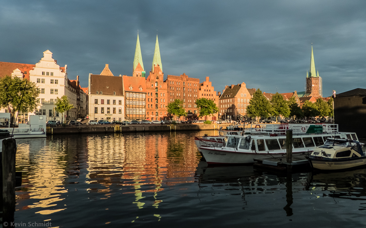 Treppengiebel und Backsteinbauweise prgen das Bild der Hansestadt Lbeck. In kontrastreicher Lichtstimmung erstrahlen die Gebude am Holstenhafen entlang der Strae An der Untertrave und auf der Altstadtinsel. Die sichtbaren Kirchtrme gehren zur Marienkirche (links) und zur Petrikirche (rechts). Die Lbecker Altstadt ist Teil des UNESCO-Welterbes. (05.08.2014)