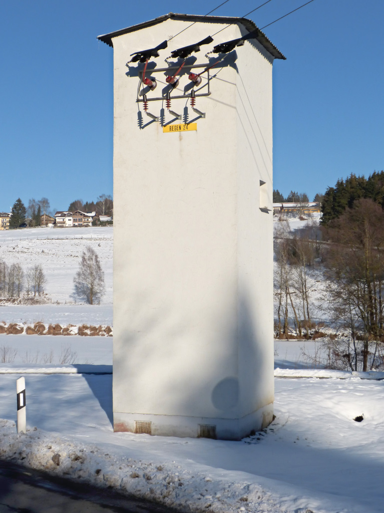 Typisch gerade im lndlichen Raum Sddeutschlands sind solche Trafoturmstationen. ber die dreiadrige 20kV Leitung wird Strom zugefhrt, der durch den Trafo auf 0,4kV heruntertransformiert wird und ber Erdkabel die umliegenden Huser versorgt. Seit ber 60 Jahren prgen solche Gebude das lndliche Idyll, werden aber immer mehr durch die kleinen Kompaktstationen ersetzt. Ortsrand von Regen 22.01.2015