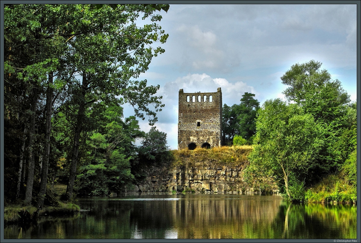 ber einem Steinbruchsee thront die Kirchenruine Nordhusen, ein berbleibsel der bereits im Mittelalter aufgegebenen gleichnamigen Siedlung. Von der um 1200 errichteten Kirche ist der 17 m hohe Westquerturm erhalten geblieben und heute Teil der Strae der Romanik. (Hundisburg, 30.07.2016)