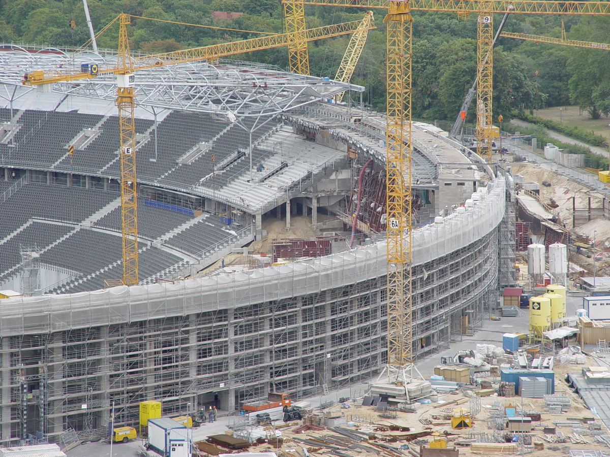 Umbau des Berliner Olympiastadion, 2000 bis 2004. Im Bereich des Sdtors, im Blid rechts, werden noch die Tribnen betoniert und schon rcken die Stahlbauer mit dem neuen Dach nach. Foto: 03.09.2003
