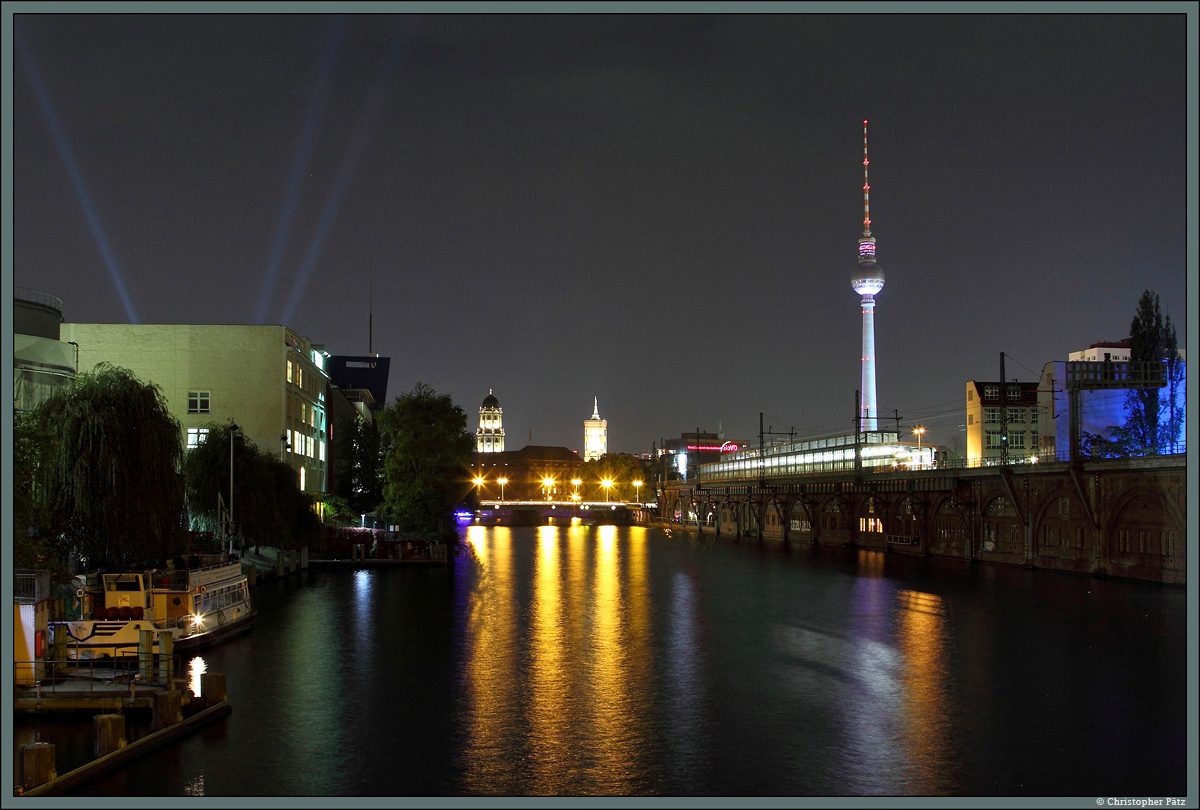 Von der Michaelbrcke sieht man am 10.10.2014 den bunt angestrahlten Fernsehturm sowie die Trme von Stadthaus und Rotem Rathaus. In der Mitte berquert die Yannowitzbrcke die Spree, rechts davon befindet sich die gleichnamige S-Bahnstation an der Stadtbahn.