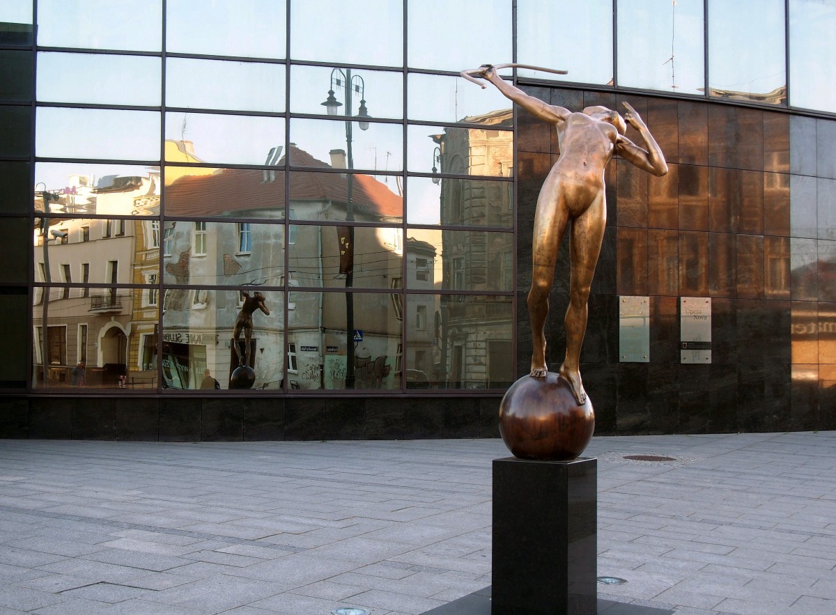 Vor der Opera Nova steht die 2013 enthüllte Skulptur einer Bogenschützin. Sie spiegelt sich ebenso wie die gegenüberliegenden Häuser in der gläsernen Fassade des Opernhauses. (2. Oktober 2015).