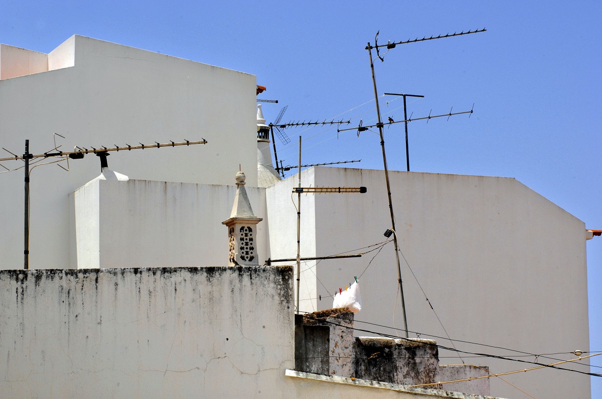 Weie Huser und Hausantennen in der portugiesischen Stadt Portimo. Aufnahme: Juli 2010.