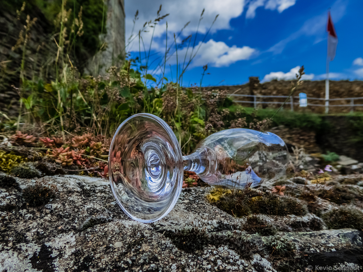 Wer mag wohl dieses Glas so kunstvoll - nicht stehend, sondern liegend! - auf ehrwrdigem Gemuer der Burg Rheinfels platziert haben? Es zeugt einerseits von geselliger Zusammenkunft, andererseits in seiner liegenden Position, wie die ruinsen Reste der einst stolzen Wehranlage oberhalb des Mittelrheins bei St. Goar, von Vergnglichkeit. (09.08.2014)